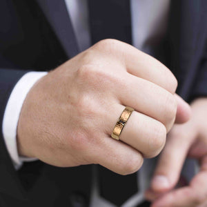 2 of 6: Close-up of a hand wearing a 6mm Hammered Bronze Cuff Ring with a dark background