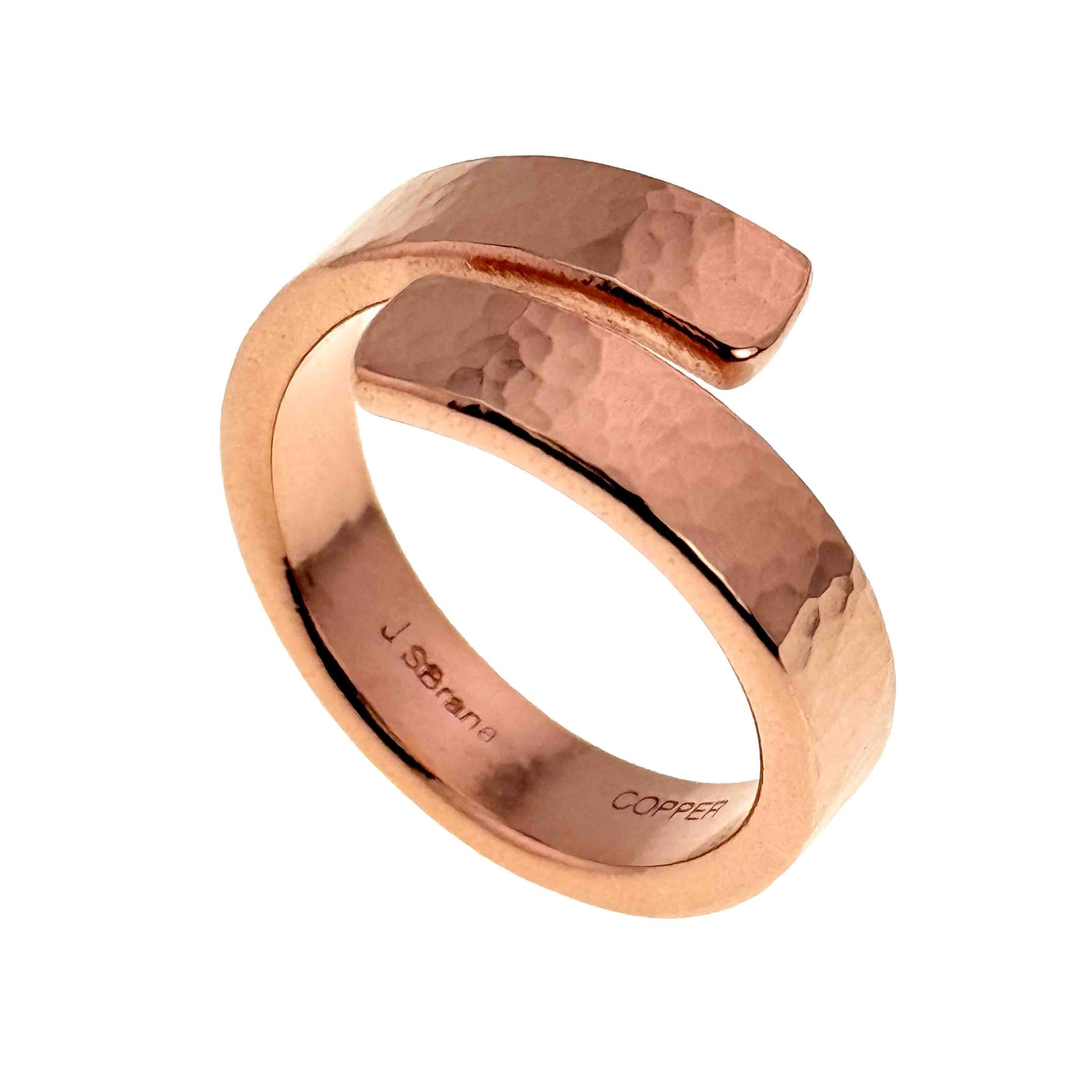 A handcrafted 6mm hammered copper bypass ring with a polished finish. The ring features a sleek, wrap-around design with a slightly curved open end. Its hammered texture adds subtle shine, and the inside of the band is stamped with "JSBrana" and "COPPER."