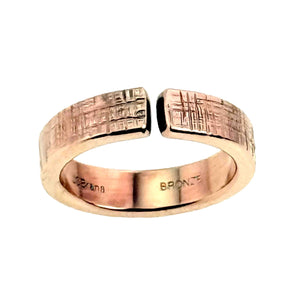 5 of 9: Close front view of the 6mm linen bronze cuff ring on a white background, showing the open cuff gap, hand applied crosshatch linen texture, polished bronze surface, rounded edges, and interior bronze stamp.