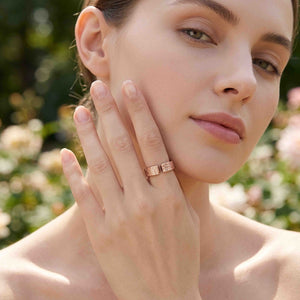 2 of 9: 6mm linen bronze cuff ring worn on a woman’s hand near her face outdoors, showing the warm polished bronze finish, open textured band, soft linen pattern, and elegant everyday style.