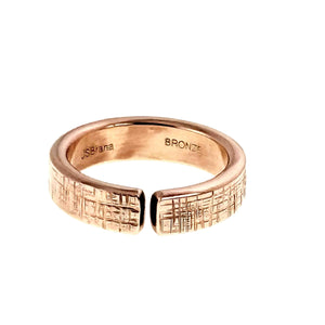 3 of 9: 6mm linen textured bronze cuff ring shown from the front on a white background, with polished warm bronze shine, open gap design, flat textured ends, rounded band edges, and interior stamps visible.