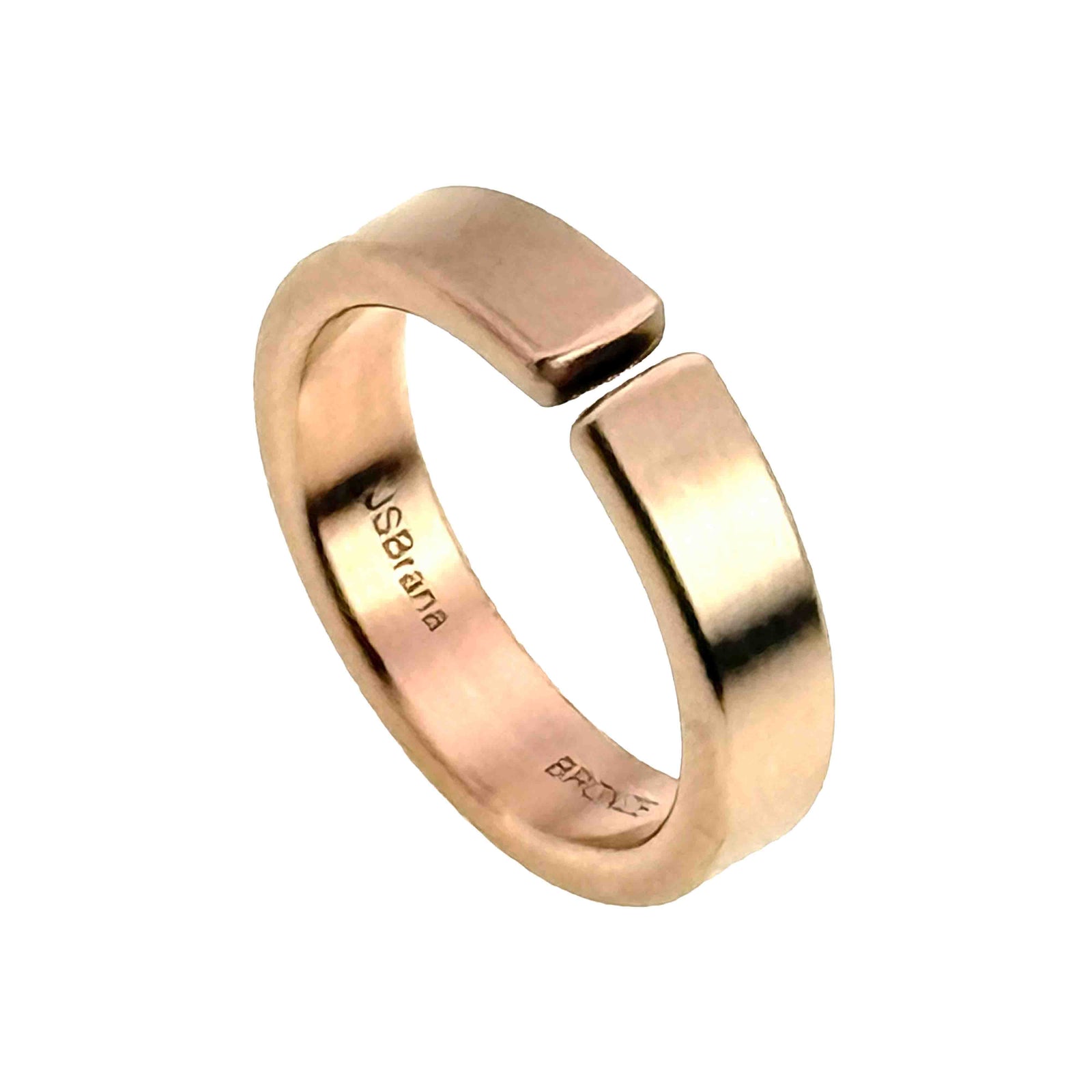 Angled view of a handmade 6mm matte bronze cuff ring standing upright on a white background, showing the open band, flat cuff ends, warm brushed finish, and interior JSBrana and BRONZE stamps.