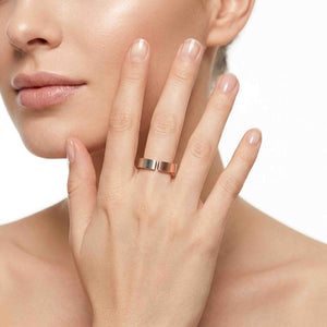 2 of 10: Close view of a woman wearing a handmade 6mm matte bronze cuff ring while resting her hand near her cheek, showing how the open band and brushed finish look on the finger against a clean white background.