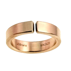 3 of 10: Rear view of a handmade 6mm matte bronze cuff ring on a white background, showing the open cuff ends, smooth inner band, warm bronze tone, and interior JSBrana and BRONZE stamps.