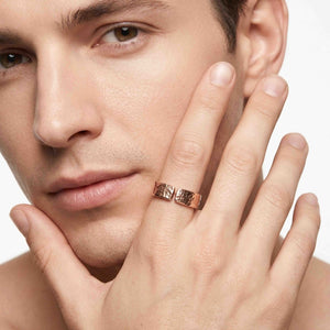 4 of 8: Man wearing a 6mm texturized bronze cuff ring with an open gap and hand-applied bark finish on his ring finger. The warm bronze ring adds a rugged, modern accent against a clean white background.