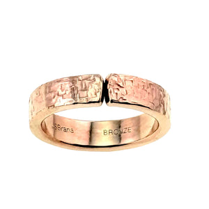 6 of 8: 6mm texturized bronze cuff ring shown front-facing with an open gap, hand-applied bark finish, warm golden bronze tone, smooth inner band, and John S. Brana and BRONZE stamps on a white background.