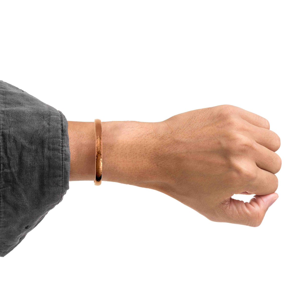 Domed hammered copper cuff bracelet on model wrist, rounded profile, hammered dimples catching light, warm copper glow.