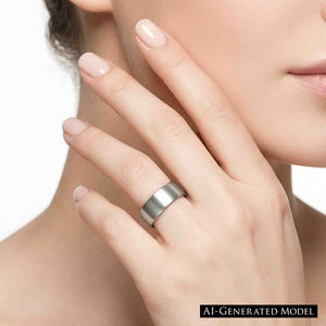6 of 8: Close up of a woman wearing a wide matte stainless steel flat band ring, showing the brushed silver finish and sleek everyday style.  AI Generated Model.
