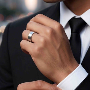 2 of 8: Man in a suit wearing a 7mm matte stainless steel flat band ring, styled as a modern unisex wedding, engagement, or anniversary band.