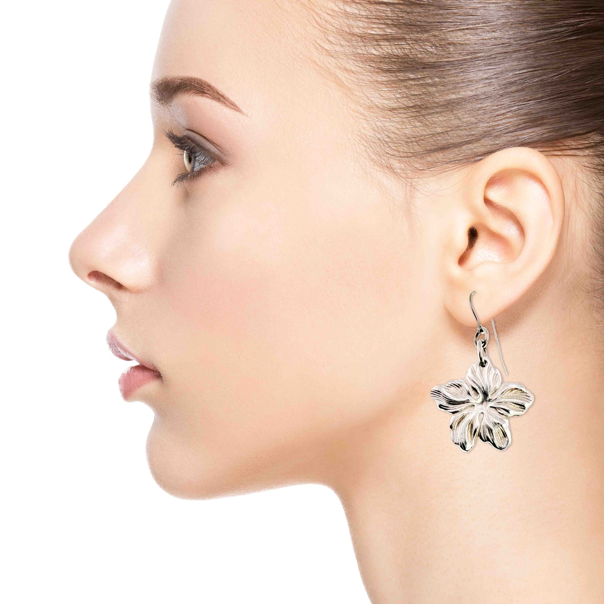 A Fashionable Woman Wearing Aluminum Hibiscus Flower Dangle Earrings
