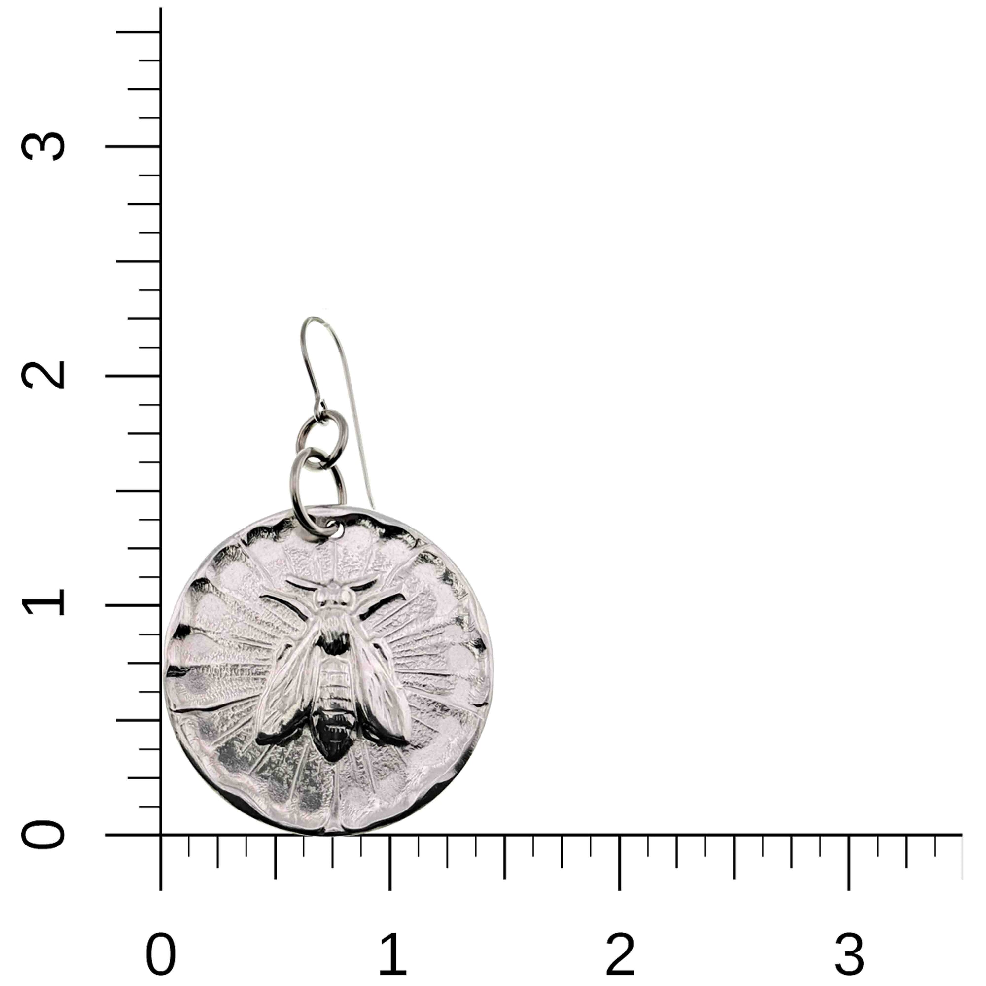 Aluminum Queen Bee Disc Drop Earrings on a ruler for scale on a white background
