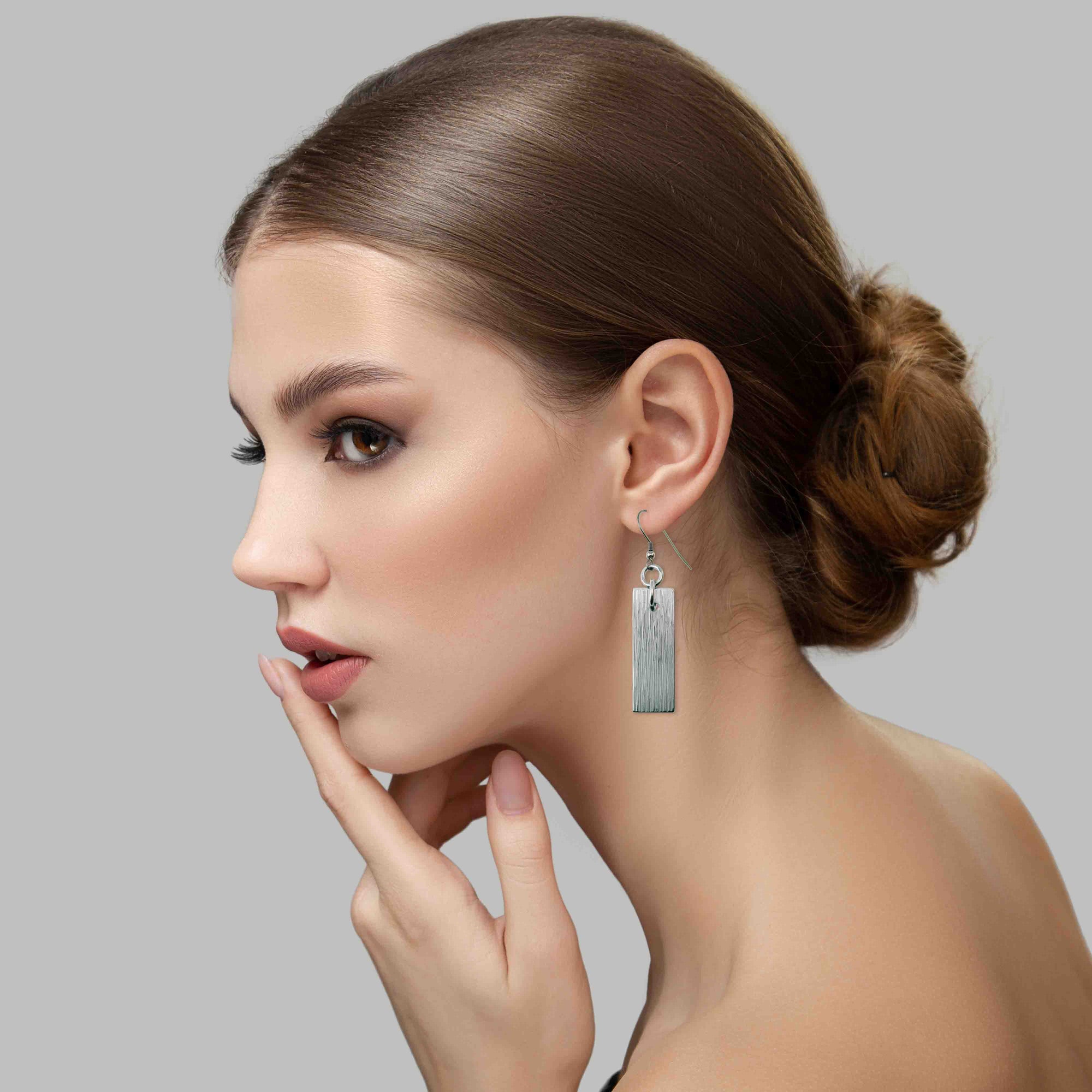 A Stunning Woman Wearing Aluminum Bark Dangle Earrings