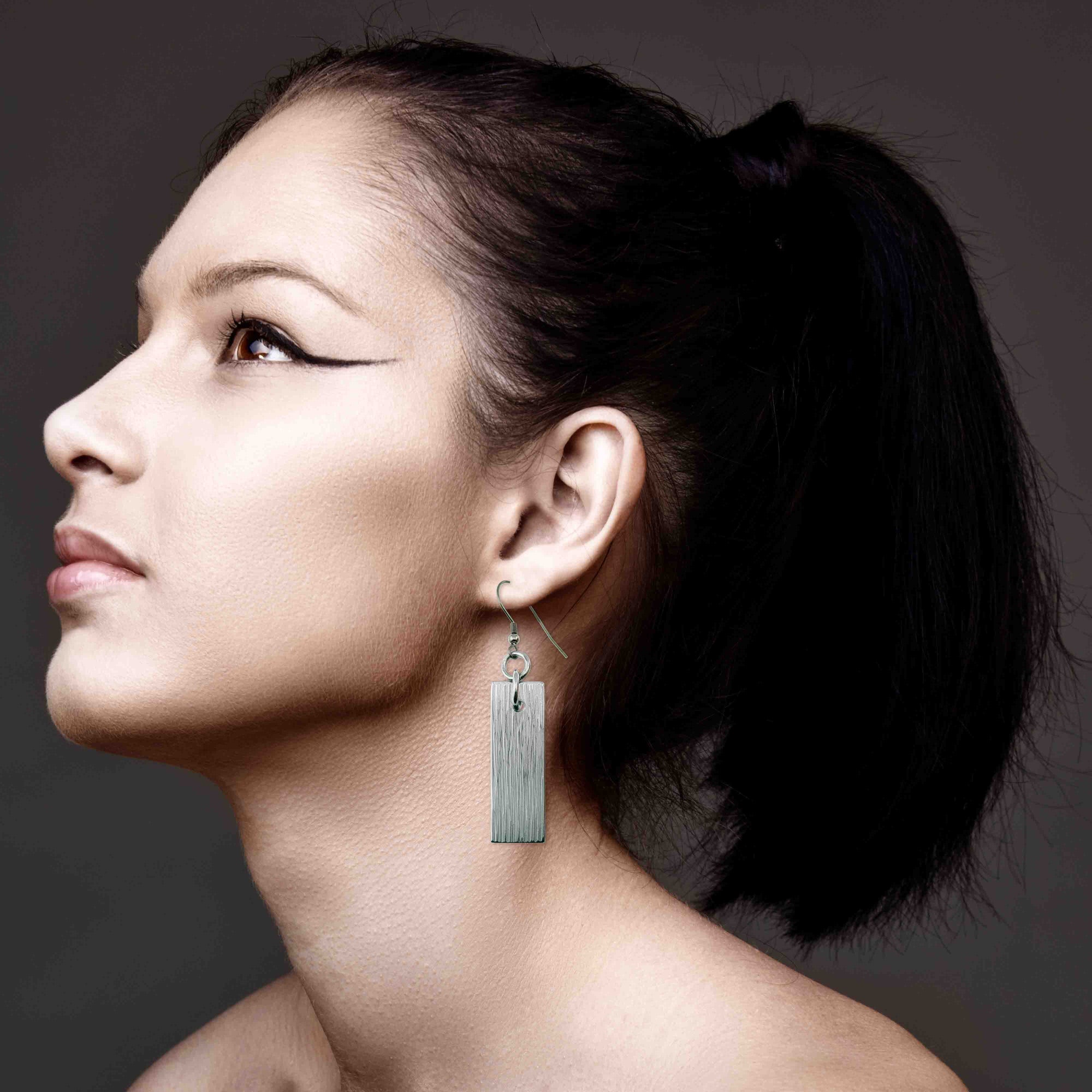 An Elegant Woman Wearing Aluminum Bark Dangle Earrings