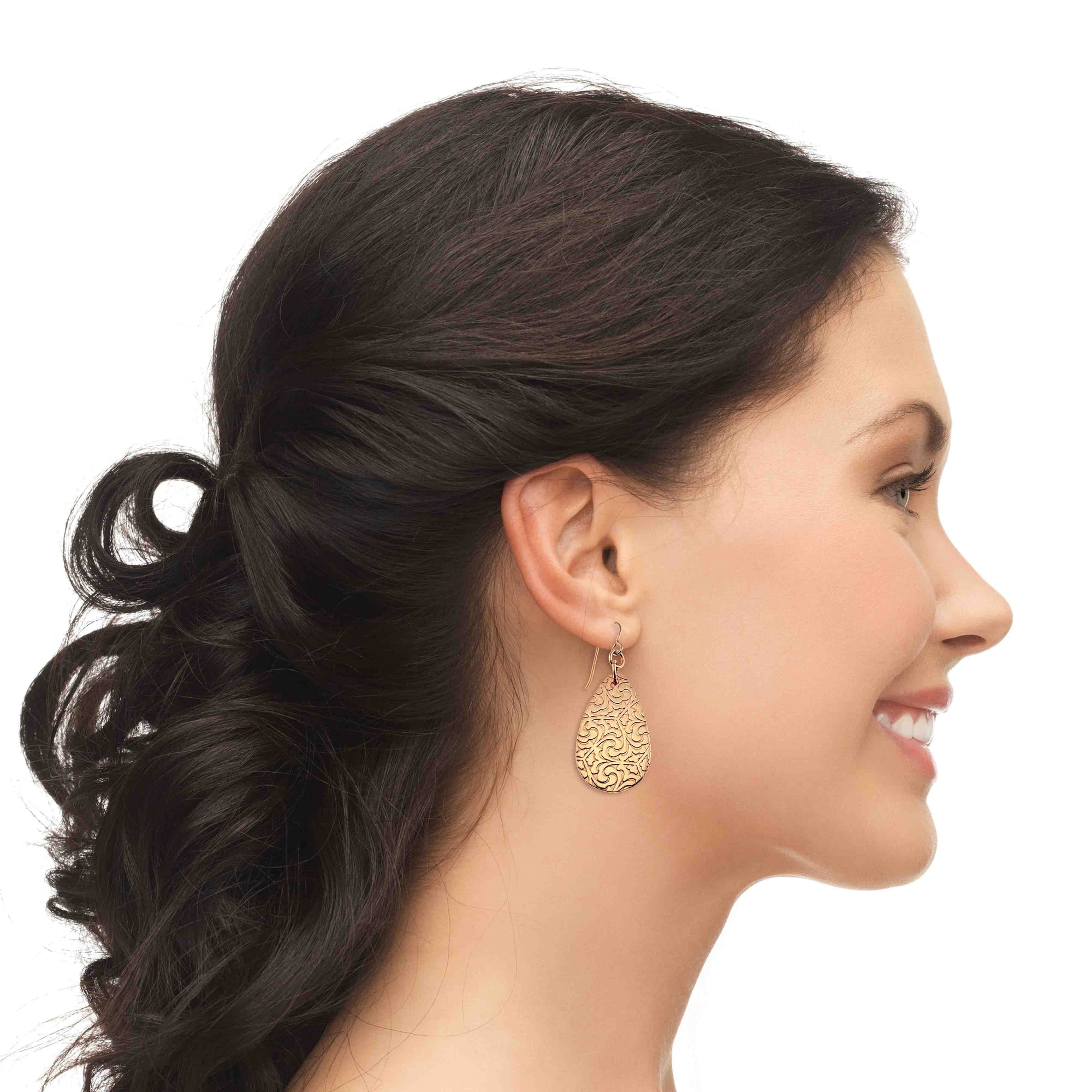 Woman wearing Bronze Damask Teardrop Earrings with a side profile on a white background