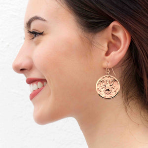 4 of 7: Woman wearing Bronze Vampire Bat Disc Dangle Earrings with a white background
