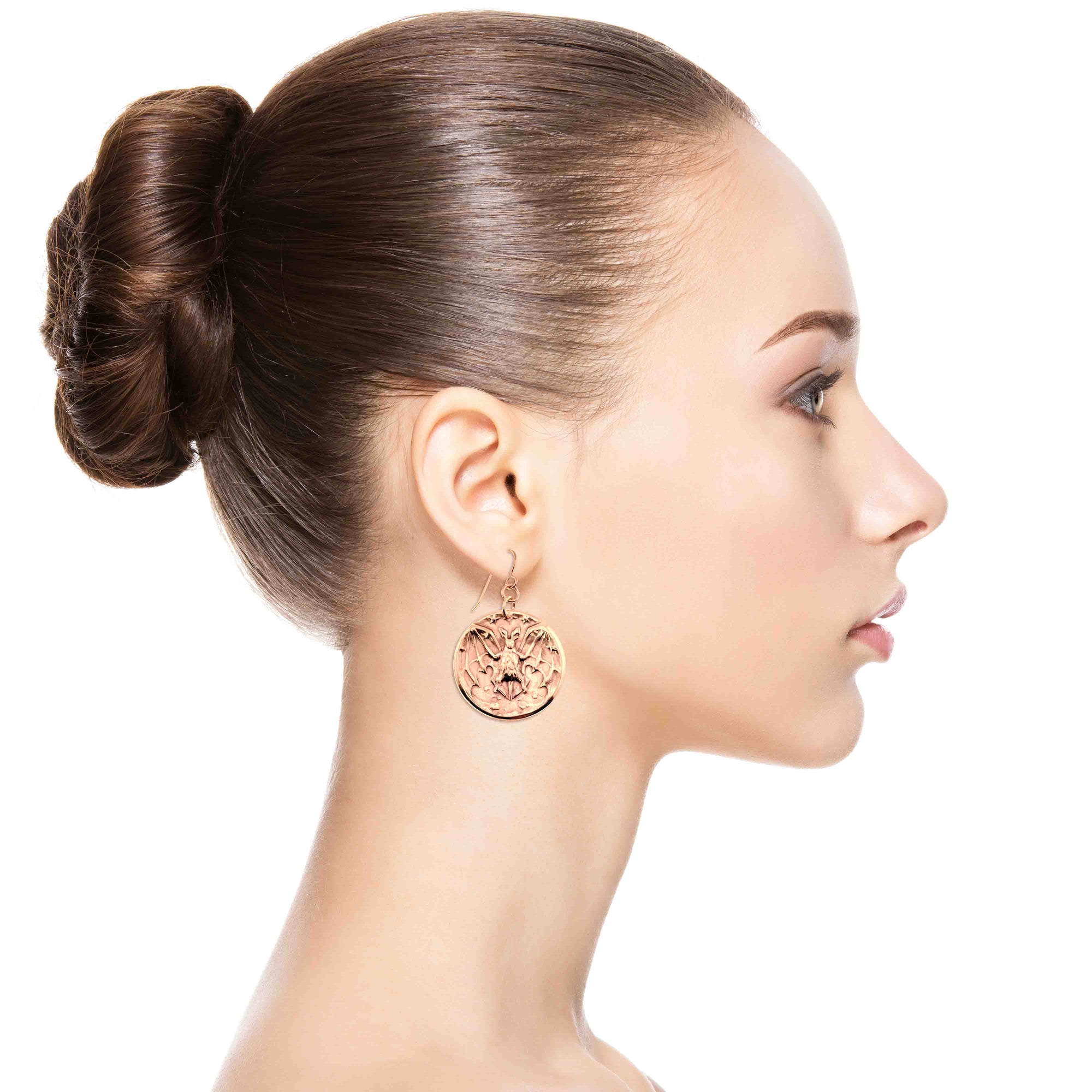Woman wearing Bronze Vampire Bat Disc Dangle Earrings with a plain background