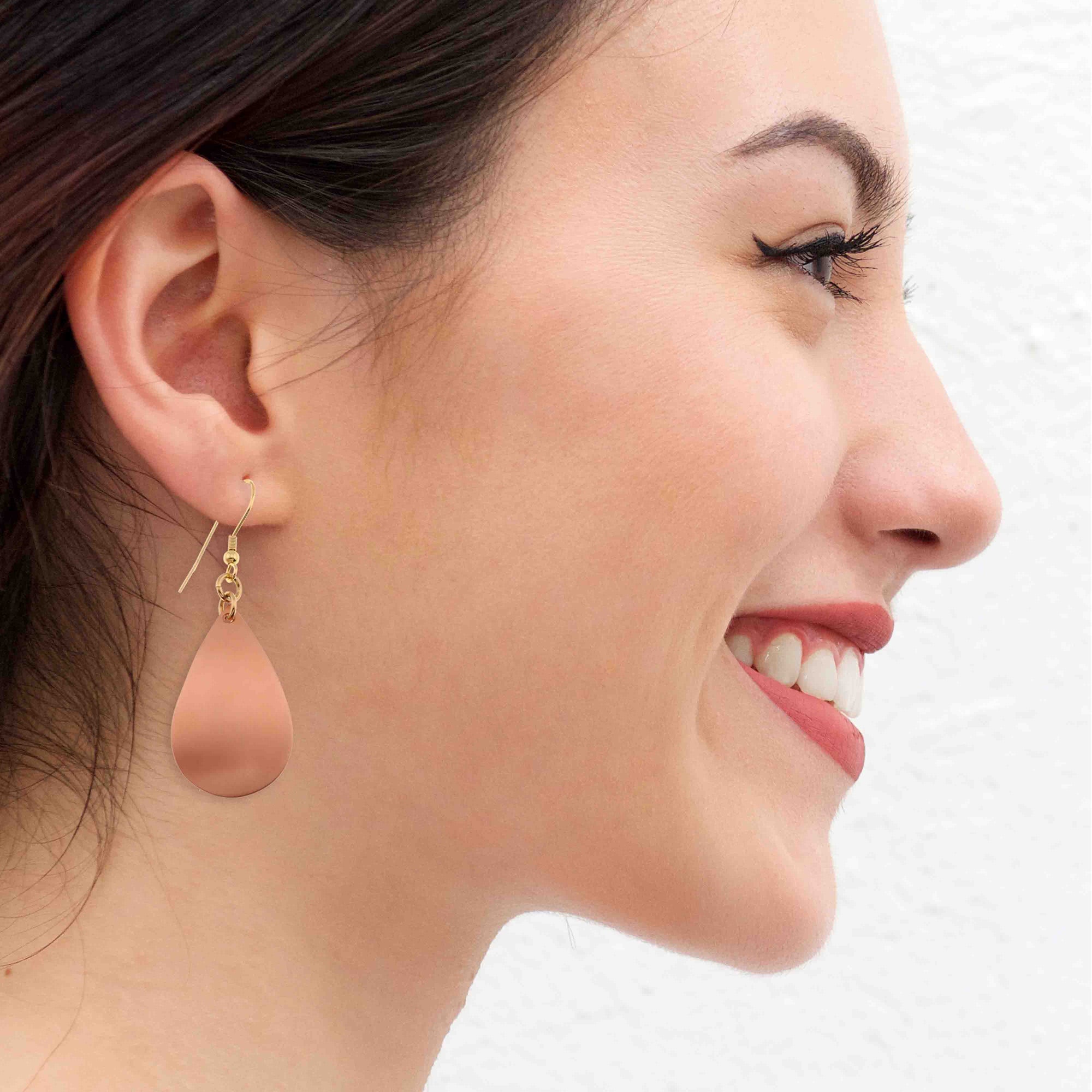 A Smiling Woman Wearing Brushed Copper Teardrop Earrings