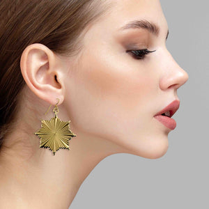 6 of 7: Christmas Starburst Nu Gold Brass Earring worn by a female model on a gray background