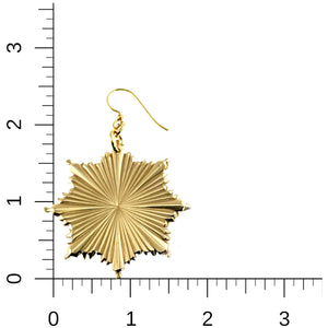 5 of 7: Gold earring with starburst design on a white background with a ruler for scale.