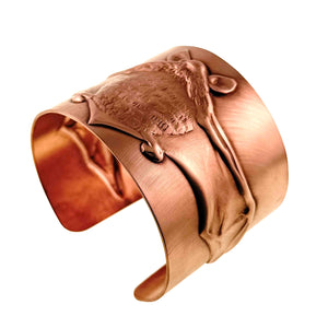 7 of 11: Three quarter view of the Copper Bat Cuff Bracelet showing the raised flying bat design flowing across the curved brushed copper surface. The open cuff shape, rounded ends, textured bat body, pointed ears, and extended wings are visible against a clean white background.