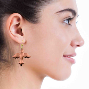 6 of 6: Close-up of a woman wearing a Copper Christmas Dove Dangle Earring with a white background