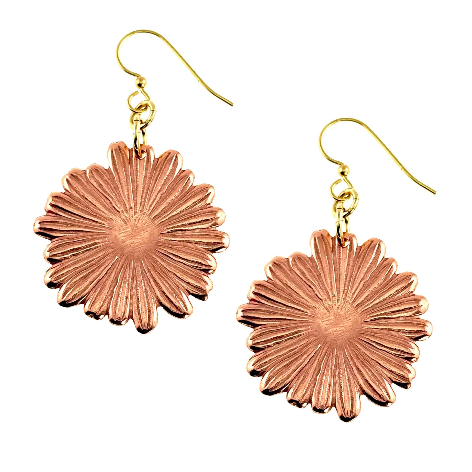 Handcrafted copper daisy dangle earrings with detailed petal texture and a polished finish, suspended from gold tone brass French hooks, shown against a clean white background. Each earring features a round floral shape with radiating lines that catch the light, creating a warm, natural glow.