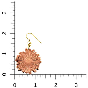 5 of 7: Handcrafted copper daisy dangle earring shown next to a measurement ruler for scale. The earring features detailed petal texture and a polished finish, hanging from a gold tone brass French hook. The image highlights its approximate 2 inch length and 1 1/4 inch width against a clean white background.