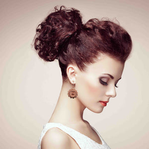 4 of 8: Woman with styled hair in an updo against a neutral background wearing Copper Daisy Disc Drop Earrings 