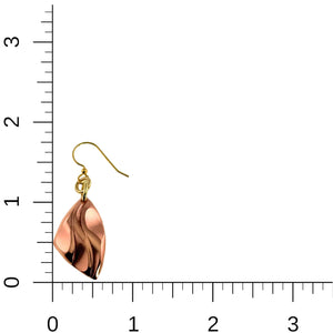 5 of 8: Single polished copper flame petal dangle earring displayed beside a ruler for size reference. The earring measures about 1 3/4 inches long and 3/4 inch wide. It features a diamond shaped copper drop with raised, flowing flame details and a shiny surface. The drop hangs from brass jump rings and a brass French hook, shown against a white background with inch markings visible.