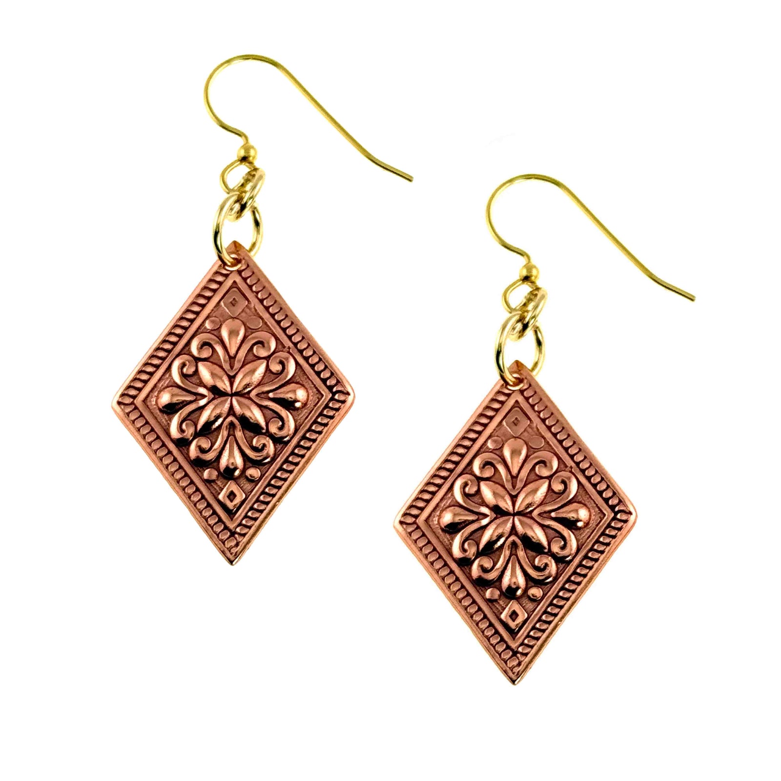 Copper floral diamond dangle earrings with polished ornate die struck flower pattern centered inside a diamond shaped copper panel. The earrings hang from gold tone brass French ear wires with small connecting rings. Warm raw copper finish with raised floral scroll details and a textured border, creating a vintage inspired look. Lightweight dangle style measuring about 2 inches long, shown on a clean white background.