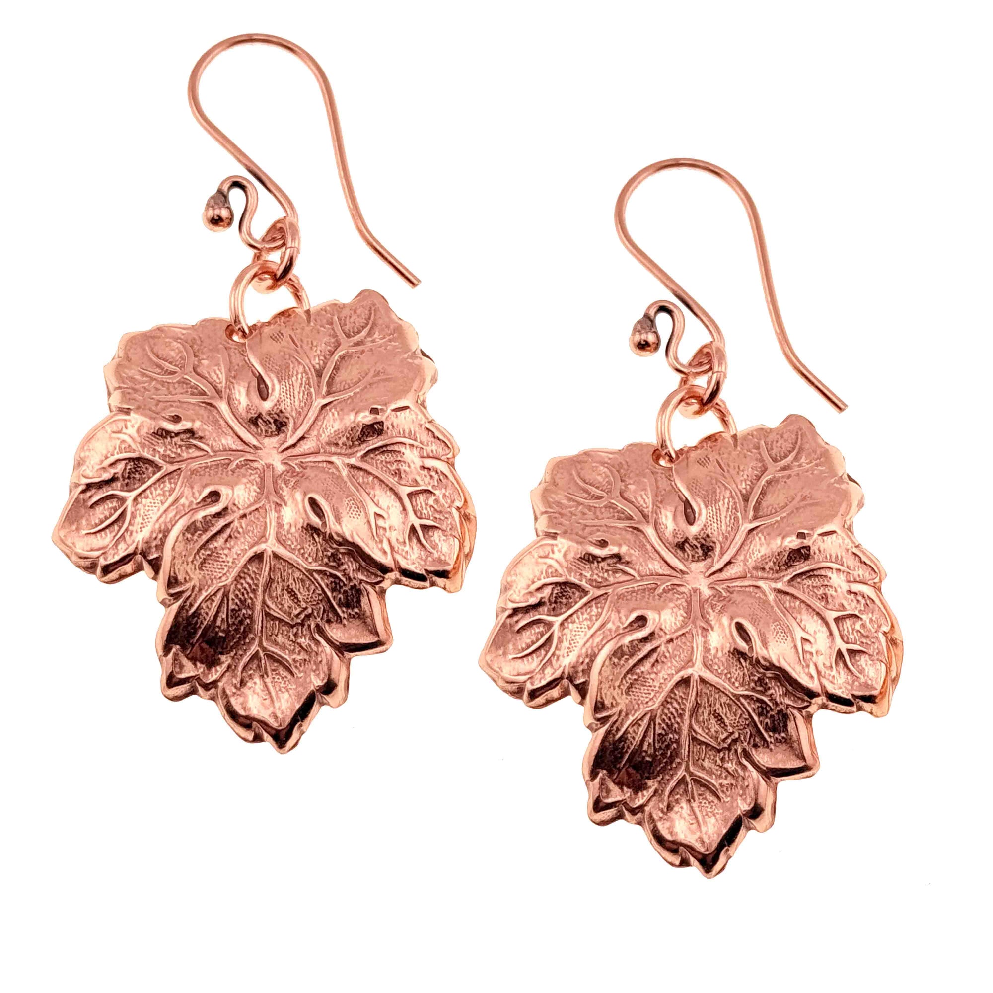 A Pair of Grape Leaf Copper Dangle Earrings on a White Background