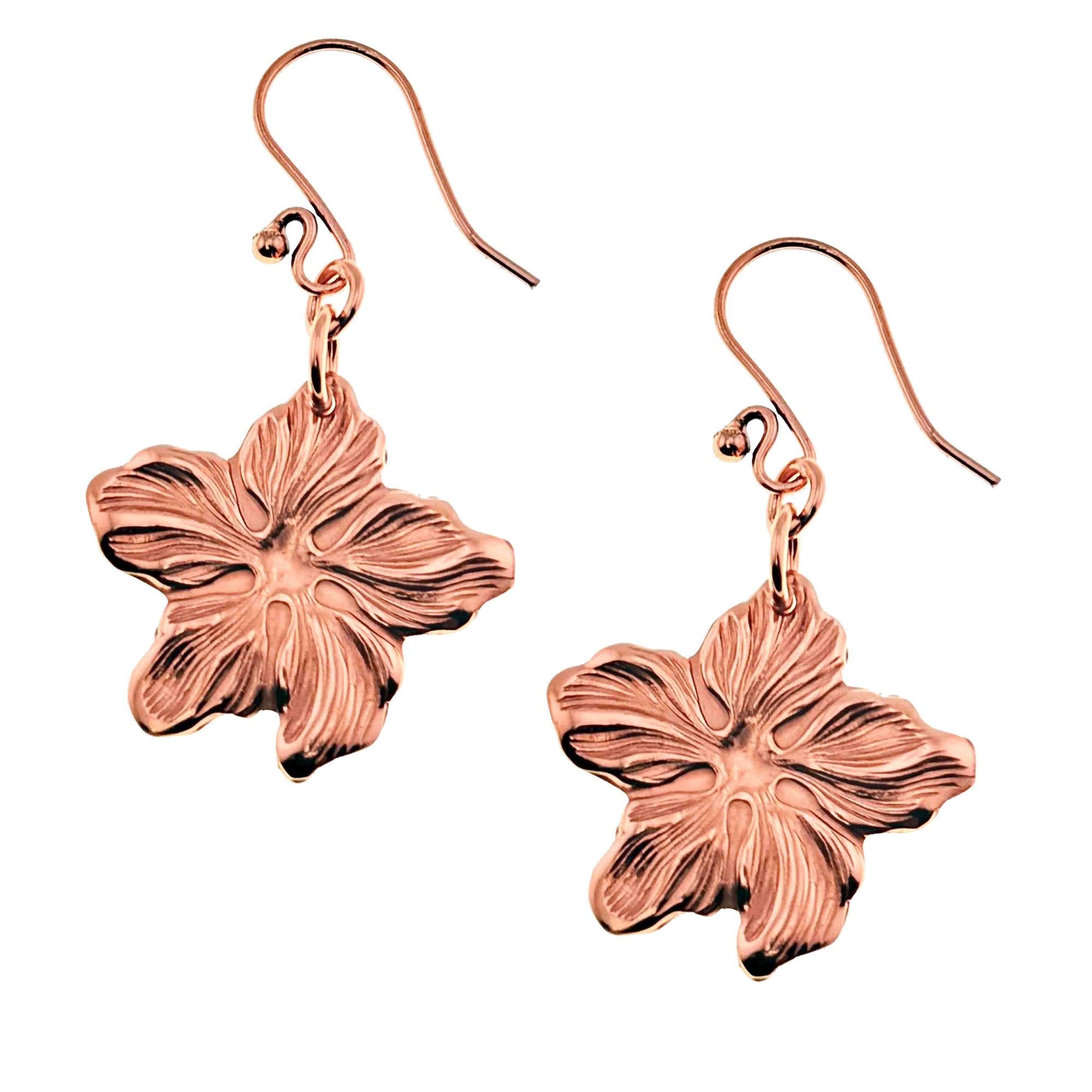 A Pair of Copper Hibiscus Flower Dangle Earrings on a White Background