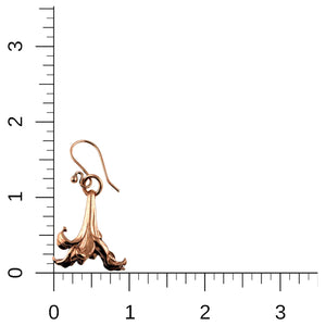5 of 7: A single copper lily flower drop earring is displayed against a white background with a black ruler grid for scale. The earring measures approximately 1 3/4 inches in length and 1 inch in width. The curved copper French ear wire and detailed petal design are clearly visible, showing the size and craftsmanship of the piece.