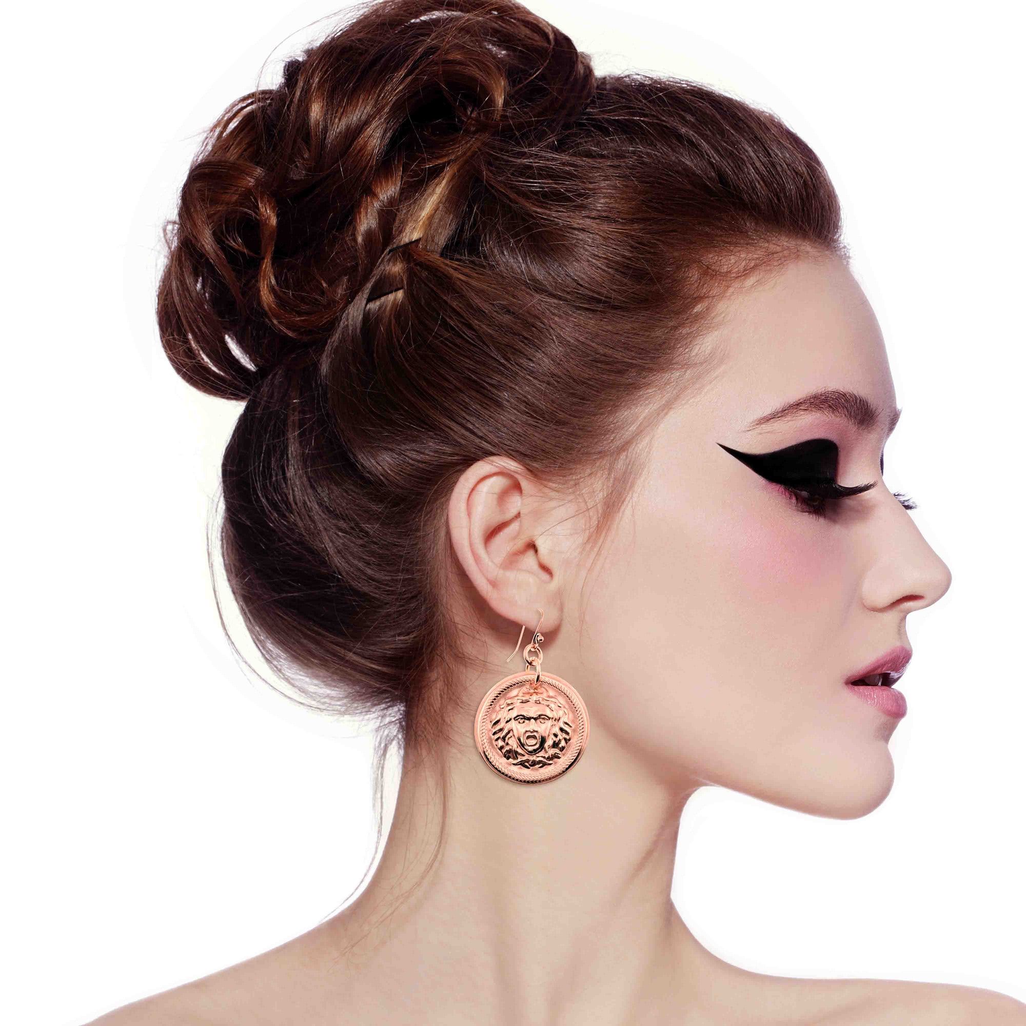 Woman with styled hair and Copper Medusa Disc Drop Earrings on a white background
