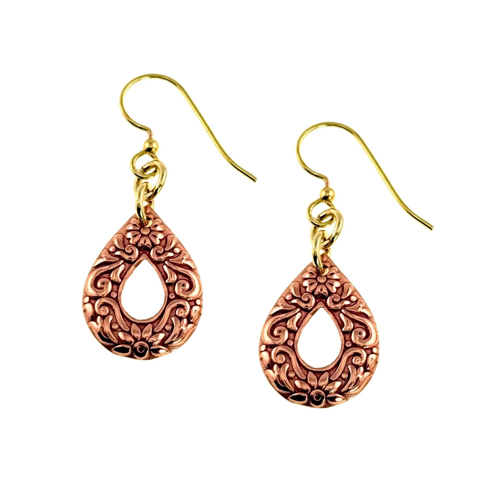 Handcrafted copper teardrop dangle earrings with ornate die struck scroll and floral pattern, open center cutout, polished raw copper finish, and brass French ear wires on a white background. Warm copper tone with detailed raised scrollwork and small floral accents surrounding the teardrop shaped opening.