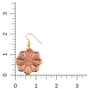 5 of 7: Product image of a single handcrafted copper flower dangle earring displayed beside a ruler for size reference. The polished eight petal bloom features raised, die struck detailing and a warm rosy copper finish. The earring hangs from a brass French hook ear wire and measures approximately 2 inches in total length and about 1 1/4 inches wide, shown against a light neutral background.