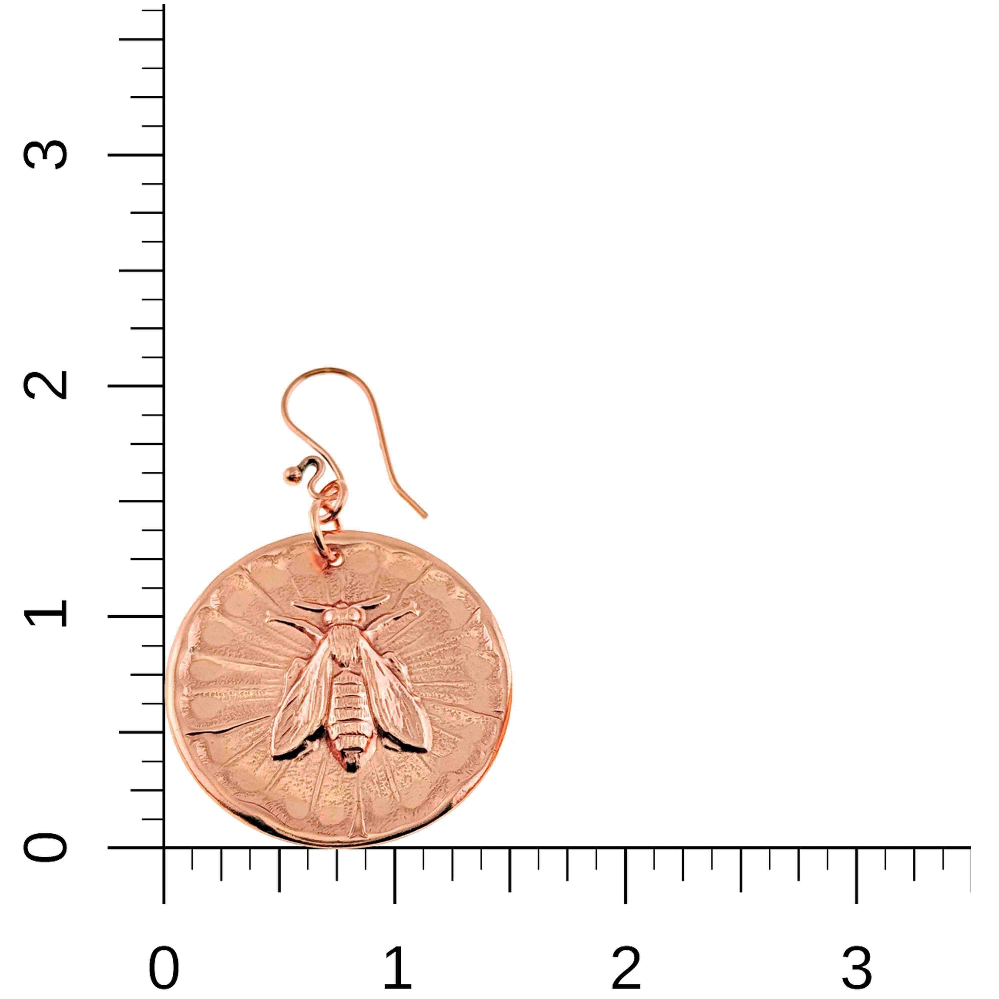 Copper Queen Bee Disc Drop Earrings on a ruler for scale