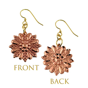 3 of 7: Front and back view of copper sunburst flower dangle earrings. The front shows polished ornate floral die struck detailing with layered petals forming a radiant sunburst pattern. The back reveals a smooth raised floral design. Each raw copper charm hangs from a brass French ear wire with small connecting rings. Warm rose copper tone stands out against a light background.