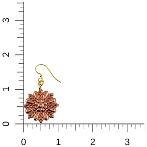 5 of 7: Copper sunburst flower dangle earring shown beside a measurement ruler for scale. The polished copper floral charm features layered petal detailing in a radiant sunburst pattern and hangs from a brass French ear wire with small connecting rings. The image highlights the earring’s approximate 1.75 inch drop length and 1 inch width against a light background with inch markings.