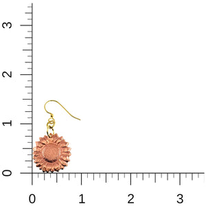 5 of 7: Close up of a single copper sunflower dangle earring shown beside a ruler for size reference. The earring measures about 1.5 inches long and features detailed petals with a textured center. It hangs from a gold tone brass French hook, highlighting its small yet eye catching floral design.