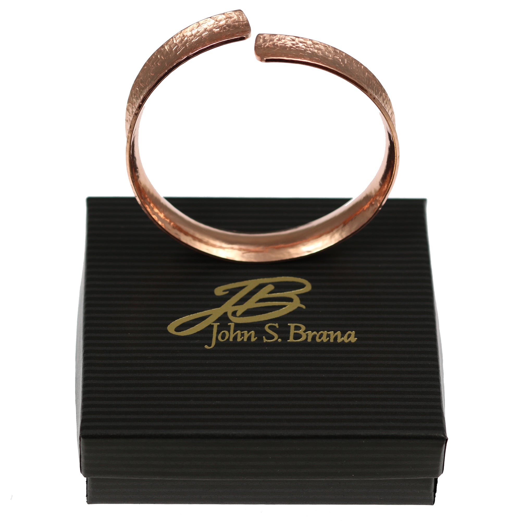 Anticlastic Texturized Copper Bangle Bracelet on top of a Black Gift Box with Gold Logo