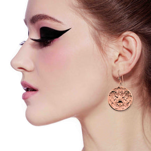 2 of 8: Close-up of a woman's profile wearing Copper Vampire Bat Disc Dangle Earrings with a white background
