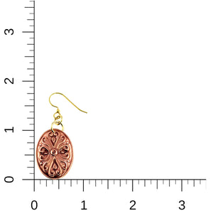 5 of 7: Product image showing a single handcrafted copper Victorian oval dangle earring with detailed scrollwork and brass French ear wire, placed beside a ruler for scale, indicating approximate length of 1 3/4 inches and width of 3/4 inch on a white background.