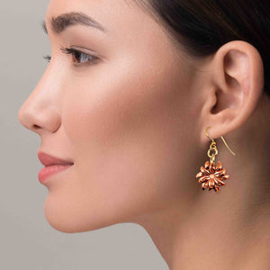 2 of 7: A Chic Woman Wearing Dainty Copper Dahlia Flower Earrings