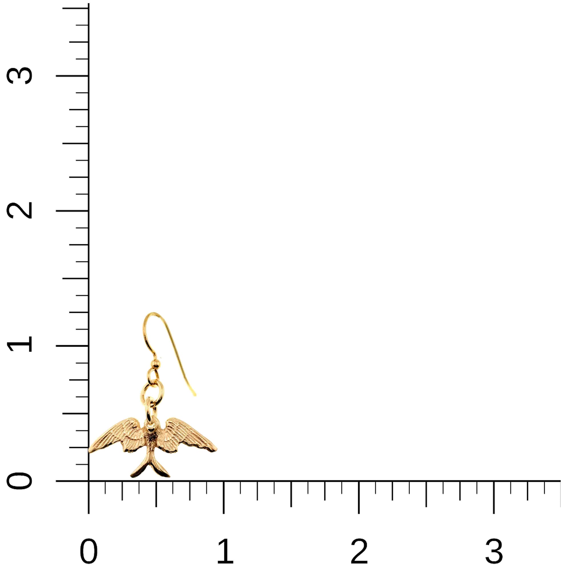 Gold bird-shaped earring on a ruler for scale