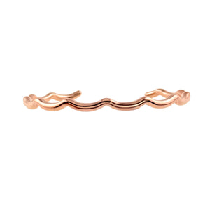 7 of 9: Side profile product image of a slim open cuff bracelet in polished copper on a white background. The narrow bracelet has softly wavy, scalloped edges and rounded open ends that curve inward. Its smooth reflective surface and warm rose copper tone highlight the handcrafted shape and clean minimalist design.
