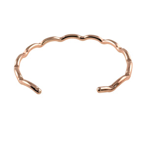 8 of 9: Product image of a slim open cuff bracelet in polished copper shown on a white background. The bracelet has a narrow band with softly scalloped, wavy edges and lightly faceted ends that add subtle texture. Its rounded open tips and warm reflective copper finish give the piece a clean, handcrafted look with a delicate modern feel.