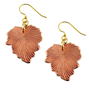 1 of 7: A pair of handcrafted copper dangle earrings shaped like grape leaves. Each earring features fine, die-struck vein detailing that mimics the natural texture of a leaf. The copper has a warm, polished finish and is paired with brass French hook ear wires. The overall design has an earthy, elegant look with a botanical flair.
