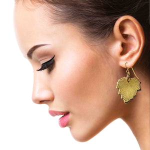 2 of 7: Close-up of a woman wearing a Grape Leaf Nu Gold Brass Dangle Earring on a white background