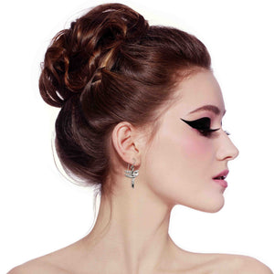 4 of 7: Woman with styled hair and dramatic makeup on a white background wearing Great Blue Heron Aluminum Earrings 